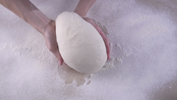 Female Hands Kneading The Dough On The Wooden Table Full Of Flour