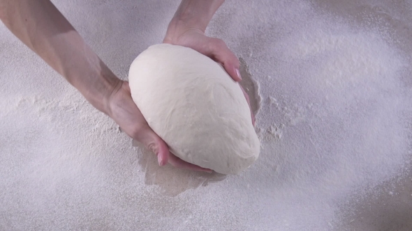 Female Hands Kneading The Dough On The Wooden Table Full Of Flour