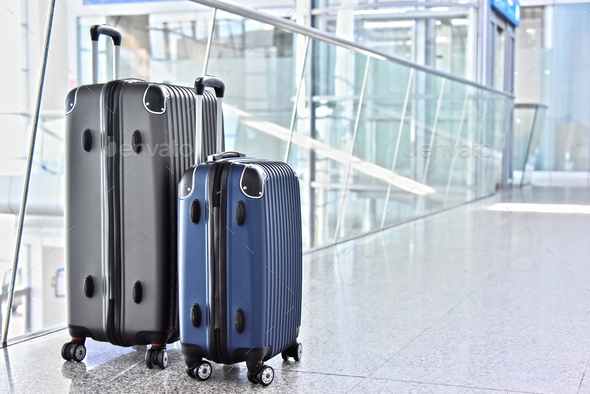 Two plastic travel suitcases in the airport hall