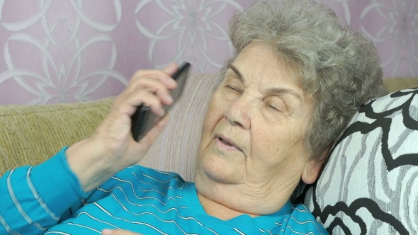 Senior Woman With Smartphone Calling At Room