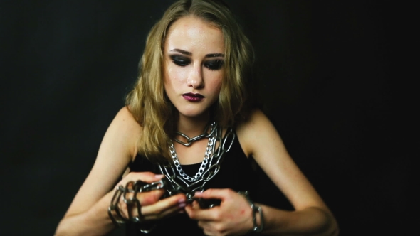 Young Woman Trying To Break The Metal Chain. alt