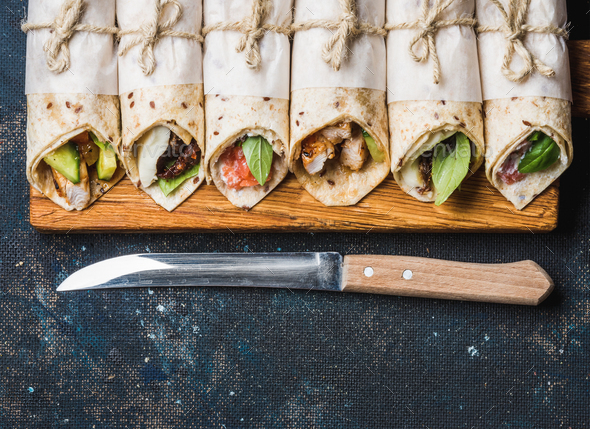 Tortilla wraps with different fillings on dark grey concrete background - Stock Photo - Images