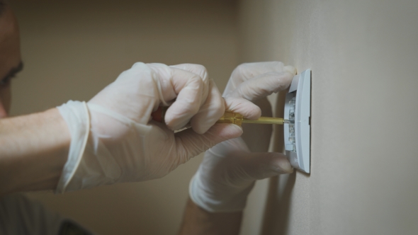 Changing Room Wall Light Switch Installation With a Screwdriver,  Electrician Hands. alt