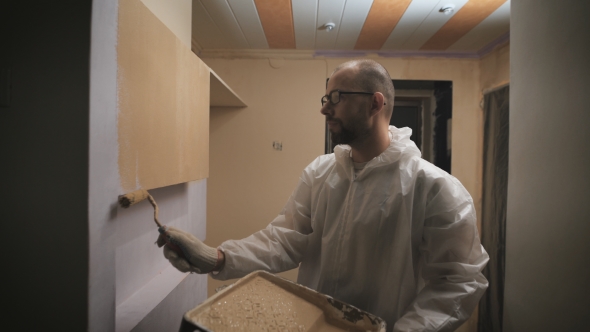 House Painter With Glasses And Beard Roller Paints The Wall. alt