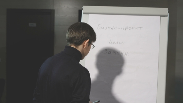 Young Man Making a Presentation About The Flip-chart.