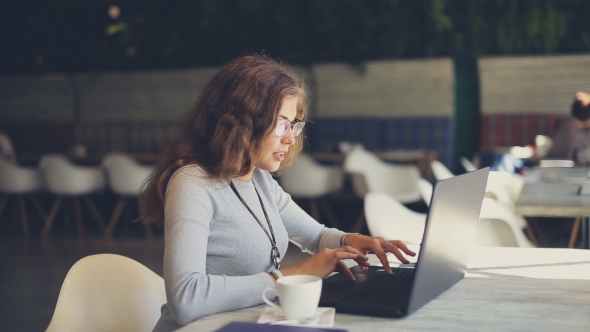 Woman With Laptop Type Text In Cafe
