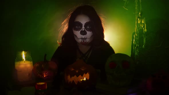 Girl with Santa Muerte Makeup Holding Pumpkin and Moves It Forward alt