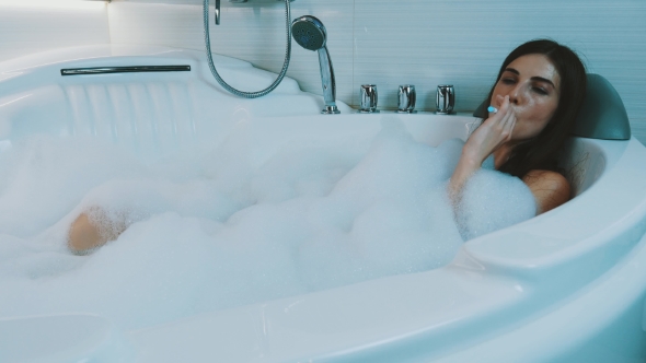 Young Girl Take Bath Full Of Foam In Bathroom. Smoke Electronic ...