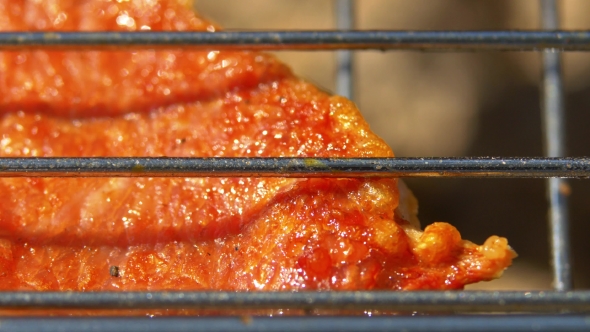 Part Of Juicy Pork Steaks Over Coals, Grilled, On The Brazier,  alt