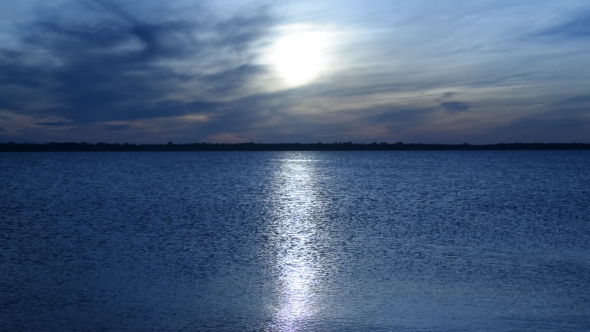 Panorama of Enormous Sun Disk and Sun-path Across Tranquil Sea Against Defocused Islands