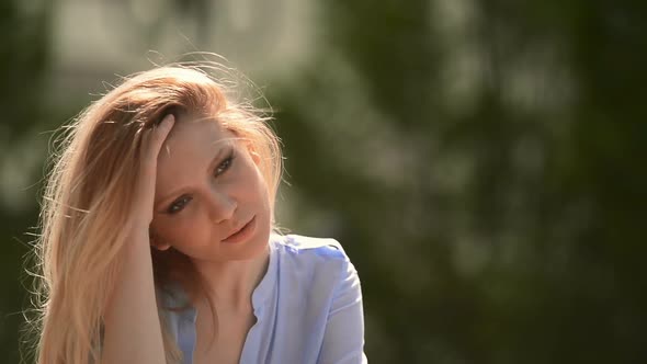 Young Beautiful Blonde Girl Portrait at Urban City Park in Summer Day