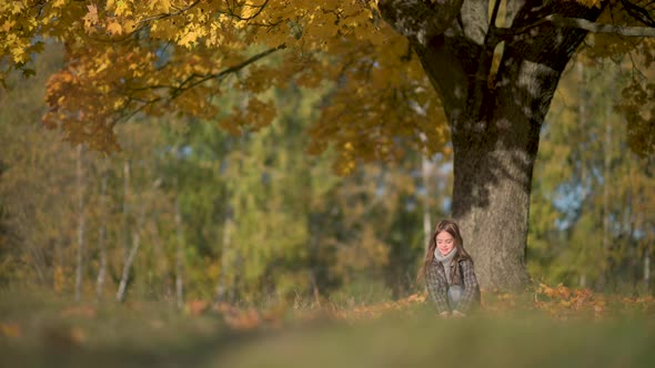 Happy Girl in a Coat Having Fun in the Autumn Park.