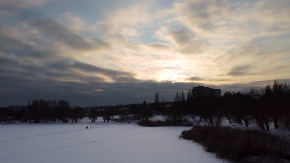 Aerial flying up on frozen wintery river in snow