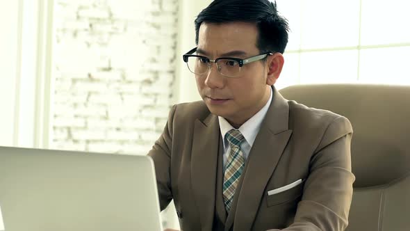 Asian Business man Working on a Laptop Intense 03 alt