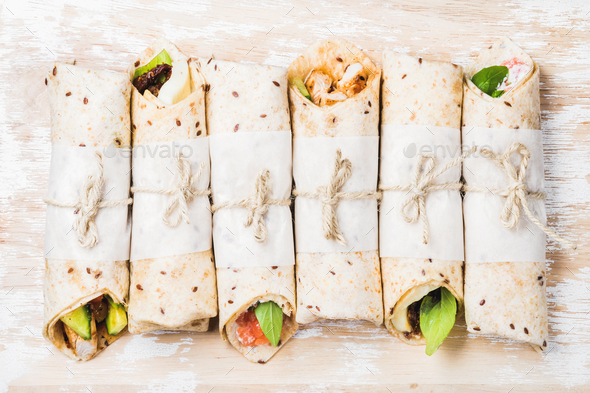Tortilla wraps with various fillings on shabby white wooden background - Stock Photo - Images