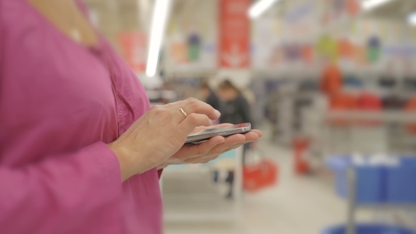 Woman Hands Using Mobile Phone In Department Store :