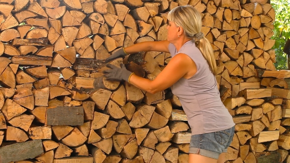 Young Woman Lays On Chopped Wood In The Woodpile