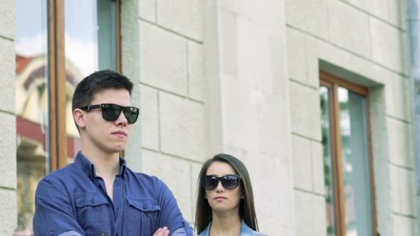 Fashion Girl In Sunglasses Draw Near Boy And Touching Him On The Street alt
