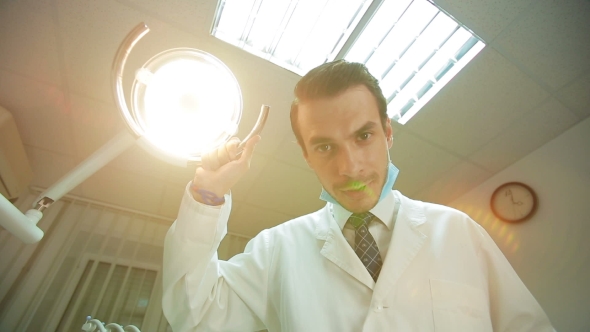 Dentist Holding Dental Lamp And Tools alt