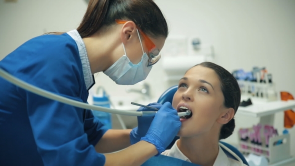 Woman Treats Teeth At The Dentist alt