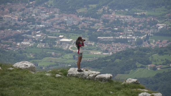 Female Traveler Photographing Town From Mountain