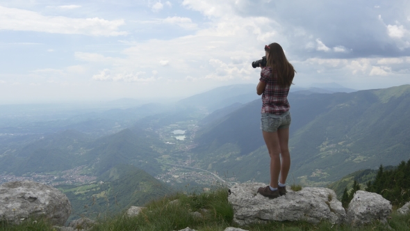 Young Woman Takes Pictures From High Mountain