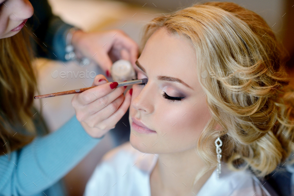 Wedding makeup artist making a make up for bride - Stock Photo - Images