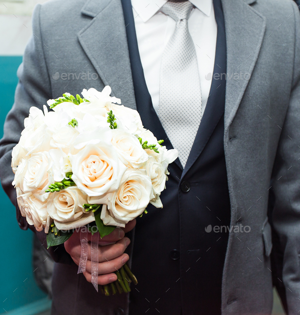 bouquet of white flowers in male hands