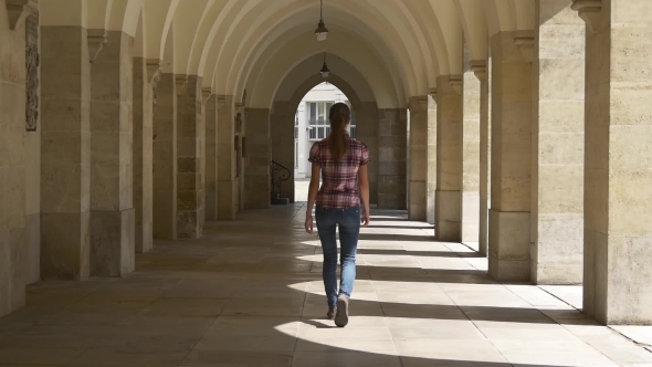 Young Woman Walking Through The Arch