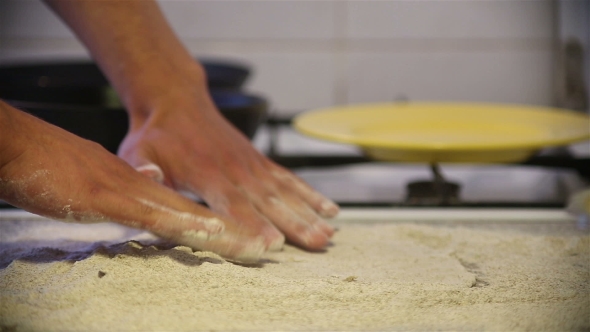 Baker Hands Kneading Dough In Flour On Table