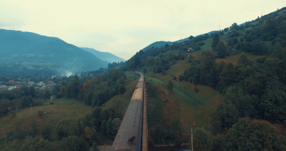 Passenger Train Rides On The Railway Bridge Across Mountain River