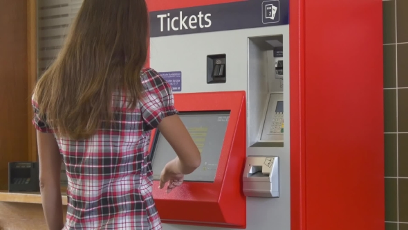 Woman Buying Ticket In Ticketing Machine