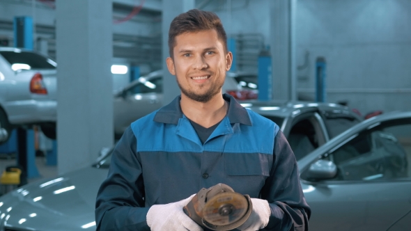 Portrait of Professional Smiling Car Mechanic Working in Modern Auto Repair Service alt