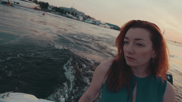 Pretty Red Hair Girl In Turquoise Dress On Motor Boat. Summer Evening. Scenery