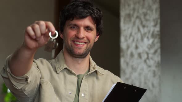 A Realtor or Real Estate Agent Shows the Key to the House He Sold alt