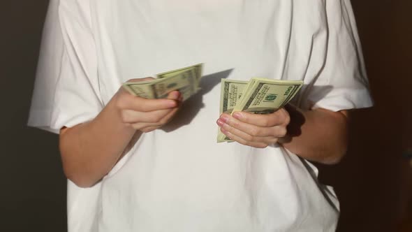 Successful woman checking amount of cash money. Close Up businesswoman hands holding one hundred dol