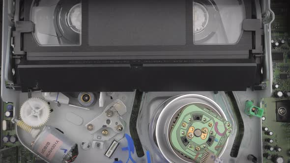 Closeup Shot Showing Inside of a Vcr While a Vhs Cassette is Being Inserted alt
