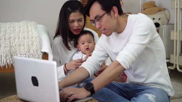 Father Working Using Laptop with His Wife and Cute Boy While Sitting on Floor in Cozy Room at Home alt