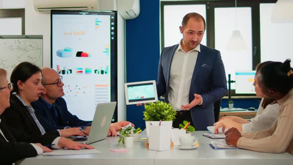 Focused Executive Manager Presenting Annual Financial Report Holding Tablet alt