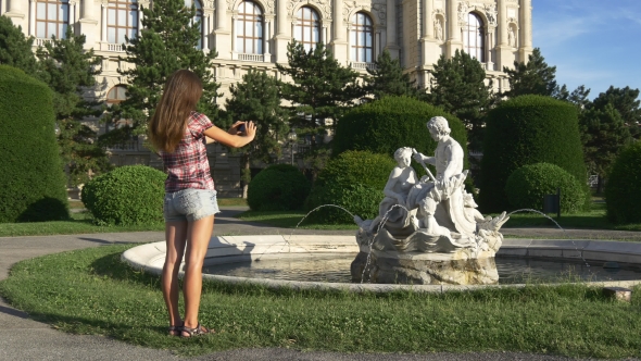 Woman Photographs a Statue on a Mobile Phone