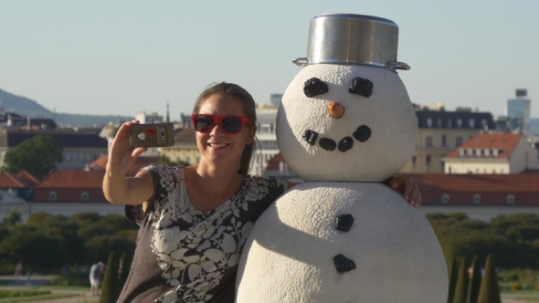 Girl Photographs Selfie In An Embrace With a Snowman In Belvedere