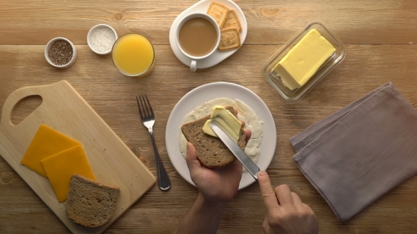 Male Hands Preparing Breakfast Toast With Butter