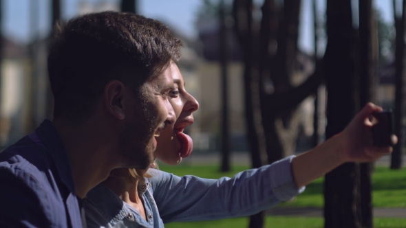 Two Casual People Play The Fool Using Mobile Phone alt