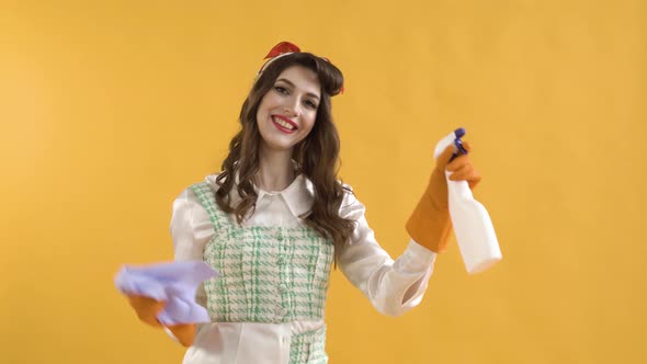 A Positive Woman Dances in Rubber Gloves with Spray and a Rag