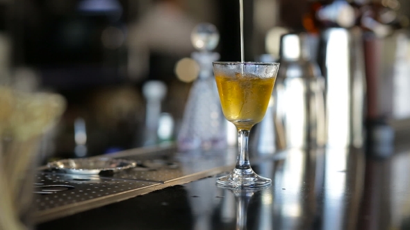 Bartender Pouring Strong Alcoholic Drink Into Small Glasses On Bar