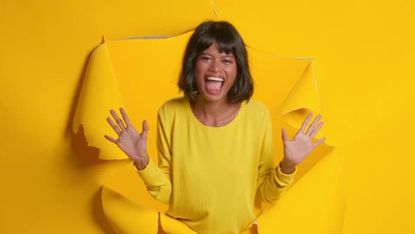 Happy Dark Skinned Woman Sincerely Smiling Posing Through Through Ripped Hole alt