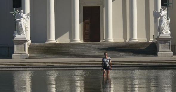Woman Walks In Water In Front Of Church