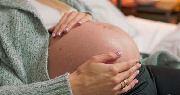 Closeup of the Pregnant Womans Belly While She is Stroking and Touching It with Her alt