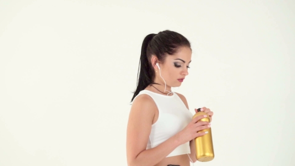 Woman With Headphones Running And Drinking Water