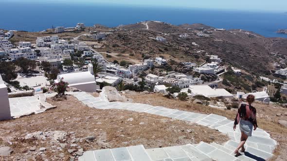 Woman walks to Chora village, on Ios island, Greece. Vacation concept alt